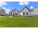 Beautiful single-Gathering home with a white brick exterior, dark shutters, a gray roof and a perfectly manicured front lawn at 3840 Shady Lake Dr, Westfield, IN 46074