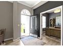 Inviting foyer with an arched transom window above the front door, gray walls, light wood floors and an office to the side at 3840 Shady Lake Dr, Westfield, IN 46074
