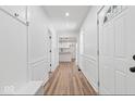 Inviting entryway with laminate flooring, wainscoting, coat hooks, and an open view into the updated kitchen at 401 N Swope St, Greenfield, IN 46140
