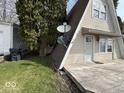 Side view of A-frame house featuring a weathered deck and mounted satellite dishes and lawn at 406 W Broadway St, Alexandria, IN 46001