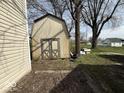 Weathered shed with double doors stands in the backyard, offering outdoor storage with trees in background at 406 W Broadway St, Alexandria, IN 46001