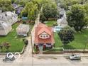 Aerial view of a charming two-story home with red roof, green lawn, and established trees at 415 E 32Nd St, Indianapolis, IN 46205