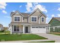 Charming two-story home with a well-manicured lawn, large windows and a two car garage on a beautiful sunny day at 4152 Dutton Dr, Bargersville, IN 46106