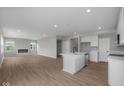 Spacious living room with hardwood floors, a modern fireplace, recessed lighting and a bright white kitchen at 4152 Dutton Dr, Bargersville, IN 46106