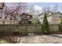 Backyard and fence with a wooden gate, tulips and a young evergreen at 5110 Riverview Dr, Indianapolis, IN 46208