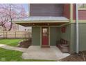Covered entryway with a bench, charming red door, and a welcoming sign above the entrance at 5110 Riverview Dr, Indianapolis, IN 46208