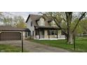 Inviting two-story home with a cozy front porch and an attached garage, nestled in a mature landscape at 543 Schooley Dr, Greenwood, IN 46142
