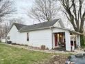 Charming home featuring a brick foundation, red front door, and a cozy front porch at 5845 South St, Stilesville, IN 46180