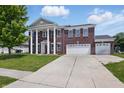 Charming exterior view of a brick home with a well-manicured lawn and a spacious driveway at 621 Fireside Dr, Greenwood, IN 46143