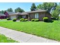 Well-manicured lawn and shrubbery enhance this brick ranch-style home's curb appeal at 6318 Dahlia Dr, Indianapolis, IN 46217