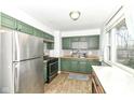 The kitchen features stylish green cabinets, stainless steel appliances, and a window at 664 N County Road 800 E, Avon, IN 46123