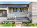 The front porch features stone accents and a wooden deck and railing leading to the front door at 7008 E Jackson St, Muncie, IN 47303