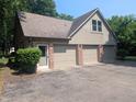 Spacious three-car garage featuring brick accents and ample parking space at 8017 Dogwood Ct, Plainfield, IN 46168