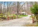 Gravel driveway and small bridge leading to a charming home surrounded by lush greenery and mature trees at 8503 Bean Blossom Rd, Trafalgar, IN 46181