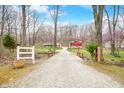 Long gravel driveway leading to a house in a wooded setting, with mature trees lining the way at 8503 Bean Blossom Rd, Trafalgar, IN 46181