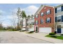 Townhomes with brick and siding exteriors, attached garages, landscaping, and private driveways at 9010 Ramapo Dr, Fishers, IN 46038