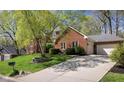 View of a brick home with well maintained grounds and a large driveway leading to attached garages at 9838 Gulfstream Ct, Fishers, IN 46037