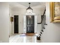 Elegant foyer with marble floors, a grand staircase, and a stylish black front door at 10605 Winterwood, Carmel, IN 46032