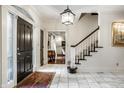 Bright foyer with a marble floor, a grand staircase, and a decorative light fixture at 10605 Winterwood, Carmel, IN 46032