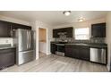 Modern kitchen featuring stainless steel appliances, dark cabinets, and a gray backsplash at 11617 Tahoe Way, Indianapolis, IN 46235