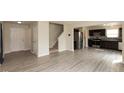 Open-concept living space featuring gray vinyl floors, stairs, and a modern kitchen at 11617 Tahoe Way, Indianapolis, IN 46235