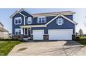 Charming two-story home with a two-car garage, beautiful blue siding and a well-manicured front lawn at 11880 Whisper Ridge Dr, Noblesville, IN 46060