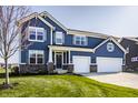 Charming two-story home with a two-car garage, beautiful blue siding and a well-manicured front lawn at 11880 Whisper Ridge Dr, Noblesville, IN 46060