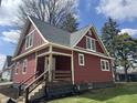 Charming red two-story home with a newly installed roof, inviting porch and landscaped garden at 128 W Walnut St, Lebanon, IN 46052