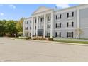 View of the building's front exterior with meticulously kept landscaping and a clear blue sky at 12820 University Cres # 3D, Carmel, IN 46032