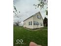 An angled view of the two-story house showing the yard and cream-colored siding at 137 S 2Nd Ave, Beech Grove, IN 46107
