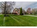 Well-maintained home with lush green lawn, mature trees and an attached garage at 13797 Mill Stream Ct, Carmel, IN 46032