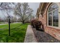 Brick home with well-kept lawn, mature tree and sidewalk at 13797 Mill Stream Ct, Carmel, IN 46032