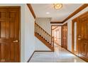 Inviting foyer with marble flooring, wooden staircase, and elegant lighting at 13797 Mill Stream Ct, Carmel, IN 46032