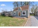 Charming bungalow featuring a light green exterior, a brown roof, and a small, quaint front yard at 1409 S Kiel Ave, Indianapolis, IN 46241