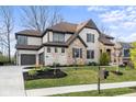 Charming home with a stone and brick exterior, complete with a curved driveway and manicured front yard at 14872 Autumn View Way, Fishers, IN 46037