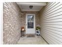 Inviting front porch, with beautiful brick and vinyl siding, decorated with plants and a decorative wreath at 17072 Newberry Ln, Westfield, IN 46074