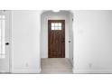 Welcoming entryway featuring a solid wood door, new flooring, and white trim at 2009 N Bosart Ave, Indianapolis, IN 46218