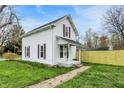Charming two-story home with fresh siding and a well-maintained front yard and sidewalk at 221 N Munsie St, Indianapolis, IN 46229