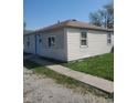 Simple, single-story home features light siding, a concrete walkway, and a functional design at 2801 Brouse Ave, Indianapolis, IN 46218