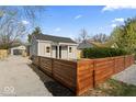 Charming home with gray siding and a new horizontal wood fence on a landscaped lot at 338 S Roena St, Indianapolis, IN 46241