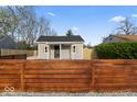A charming home featuring gray siding, a black roof, and a newly installed horizontal wood fence at 338 S Roena St, Indianapolis, IN 46241