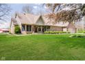Beautiful brick home featuring a lush green lawn, complemented by mature trees and tasteful landscaping at 3718 S County Road 101 E, Clayton, IN 46118