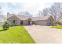 Charming brick home with well-manicured lawn, mature trees, and long driveway leading to an attached garage at 5875 Annanhill Ct, Avon, IN 46123