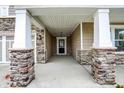 Inviting front porch with stone columns and a view of the front door and well-maintained entry at 6103 Pebblebrooke Rd, Whitestown, IN 46075