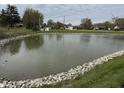 Scenic pond view featuring rocky shoreline and surrounding green landscape at 6318 Amarillo Way, Indianapolis, IN 46237