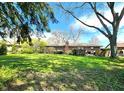 Expansive backyard featuring lush green grass, mature trees, and a brick chimney at 6723 Balmoral Rd, Indianapolis, IN 46241