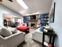 Open-concept living room with a fireplace, built-in shelves, and a view into the kitchen at 6723 Balmoral Rd, Indianapolis, IN 46241