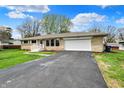 Well-maintained single-story home with stone exterior, attached garage, and driveway at 6826 Hague Rd, Indianapolis, IN 46256