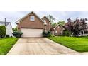 Front exterior showcasing brick facade, attached garage, and landscaped greenery with a concrete driveway at 7131 Topp Creek Ct, Indianapolis, IN 46214