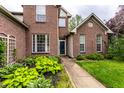 Detailed view of the front entrance with lush hosta landscaping and a brick facade at 7131 Topp Creek Ct, Indianapolis, IN 46214